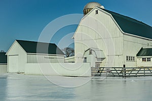 Large White Barn with Silo in Winter Snow