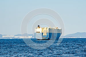 Large White and blue Roll-on/roll-off RORO or ro-ro ships or oceangoing vehicle carrier ship anchor in the open sea. Roro ship