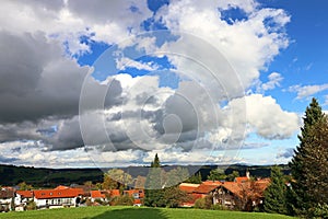 Large white clouds in the blue sky above a village in Bavaria