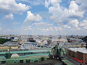 Large white clouds and blue sky over the roofs