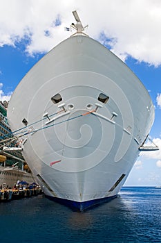 Large white cruise ship docked in the port front bow view