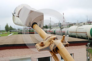 A large white industrial waterproof lantern on a building with a large plafond on the background of a railway