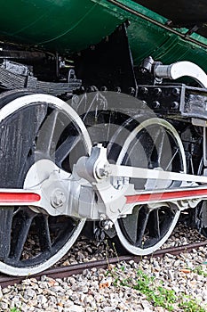 Large white iron wheels of an old locomotive close-up vertical photo