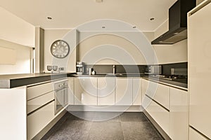 a large white kitchen with a clock on the wall