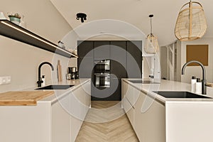 a large white kitchen with two sinks and black appliances