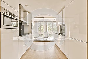 a large white kitchen with white cabinets and a window