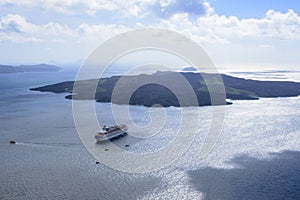 Large white passenger cruise liner in the old port of the Greek city of Fira.