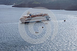 Large white passenger cruise liner in the old port of the Greek city of Fira.