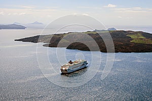 Large white passenger cruise ship in the old port of the Greek city of Fira. Sunset. Travel. Cruises