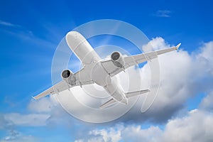 large white passenger plane flies high above of beautiful clouds on blue sky background