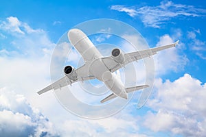 large white passenger plane flies high above beautiful clouds on blue sky background