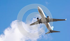 A large white passenger plane takes off. Cargo and passenger transportation. Flight to the summer resort. Clear blue sky. Airplane