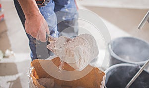 Large white plastic construction bucket with spatula and plaster, tiled glue, cement for the repair of an apartment, house,