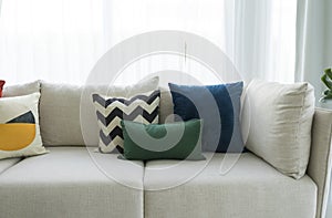 Large white sofa with colorful cushions in a spacious living room interior