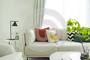 Large white sofa with colorful cushions in a spacious living room interior