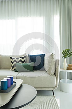 Large white sofa with colorful cushions in a spacious living room interior