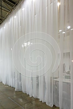 Large white tulle curtains divide the space into two parts