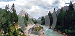 Large wide back view. Couple are sitting on a large stone, a boulder, among the incredibly beautiful river of turquoise color, photo