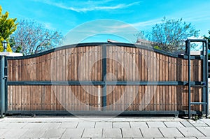 Large wide and tall wooden gate against a clear blue sky. Rustic Wood Background with Texture.