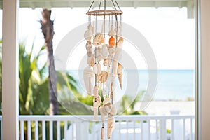 large wind chime made of seashells on beach house porch