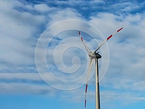 Large wind generator close-up against the background of the sky and clouds. Copy space