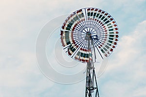 A large wind turbine in the blue sky on a cloudy day.