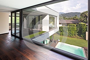 Large window in hallway of modern villa overlooking the private