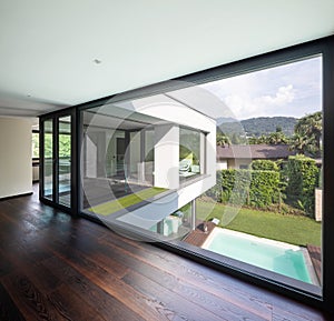 Large window in hallway of modern villa overlooking the private