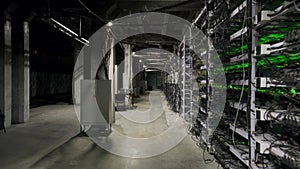 Large wired internet datacenter storage. Cryptocurrency mining equipment on large farm. ASIC miners on stand racks mine