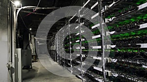 Large wired internet datacenter storage. Cryptocurrency mining equipment on large farm. ASIC miners on stand racks mine