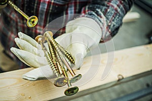 Large Wood Construction Screws in the Worker Hands
