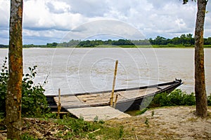 A large wooden boat tied to the river bank. This is a big river crossing Boat. A beautiful river of Bangladesh