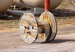 Large wooden bobbin at worksite, used to carry roll of cables