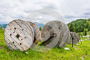 Large wooden cable pulleys with electric cables. Cable reels, cable drums lying on the construction site.