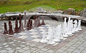 Large wooden chess pieces on board outside