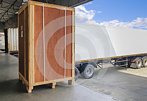 Large Wooden Crate Loading into Shipping Cargo Container. Truck Parked Loading at Dock Warehouse. Supply Chain Shipment Logistics.