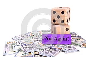 Large wooden dice sitting on top of scattered US dollars. Concept gambling on your future savings and investments.