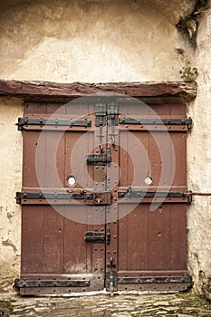 A large wooden door closed an old fortress in the stone wall of the castle in Germany on the Rhine River