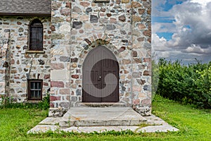 Large, wooden door to St. Andrews Anglican stone church in Heward, SK