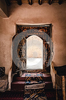 Large wooden door in a traditional Moroccan house. Gate with crafted wooden symbols. Classic Arabic architecture