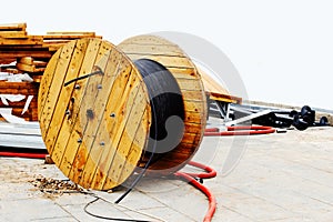 Large wooden reel with industrial power cable. Construction of power lines. Close-up. Copy space