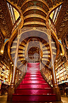 Large wooden staircase with red steps inside library bookstore Livraria Lello in historic center of Porto, famous for Harry Potter