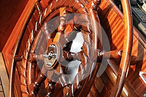 Large wooden steering wheel of a classical sailing yacht.