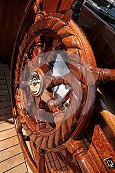 Large wooden steering wheel of a classical sailing yacht.