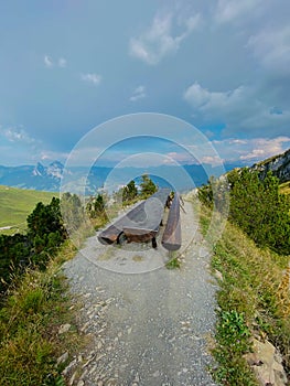 Large wooden table with benches for relaxing on an alpine trail in the Swiss Alps