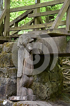 Large Wooden Troll Under a Bridge in the Woods