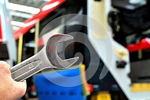 Large wrench on a background of a railway carriage inside a factory workshop. Rail car assembly plant. Industrial workshop for the