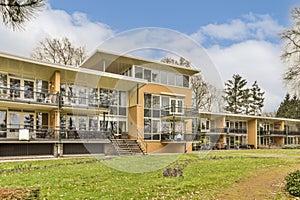 a large yellow house with glass windows on a hill