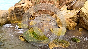 Large yellow sand stones boulders rocks on sandy beach of the sea shore. Natural