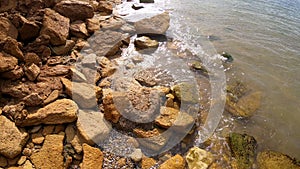 Large yellow sand stones boulders rocks on sandy beach of the sea shore. Natural